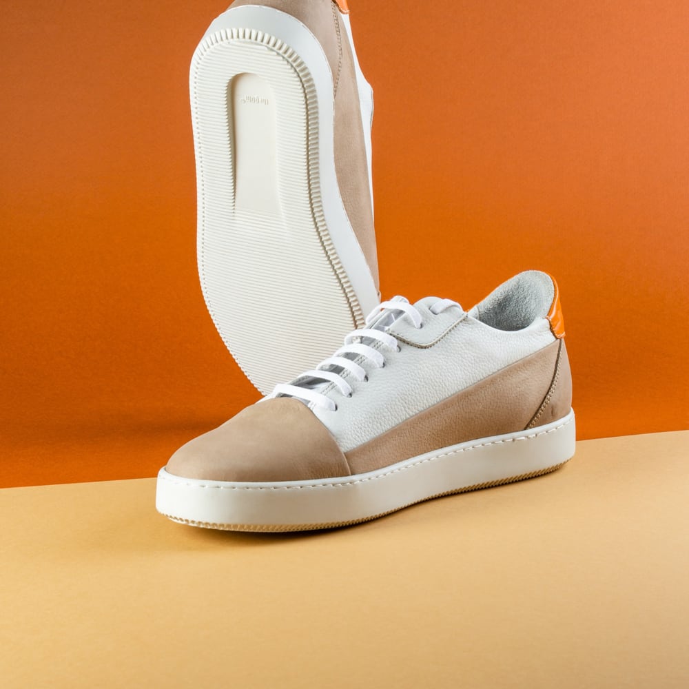 A pair of brown and white sweade sneakers with rubber outer sole. View images in gallery mode.